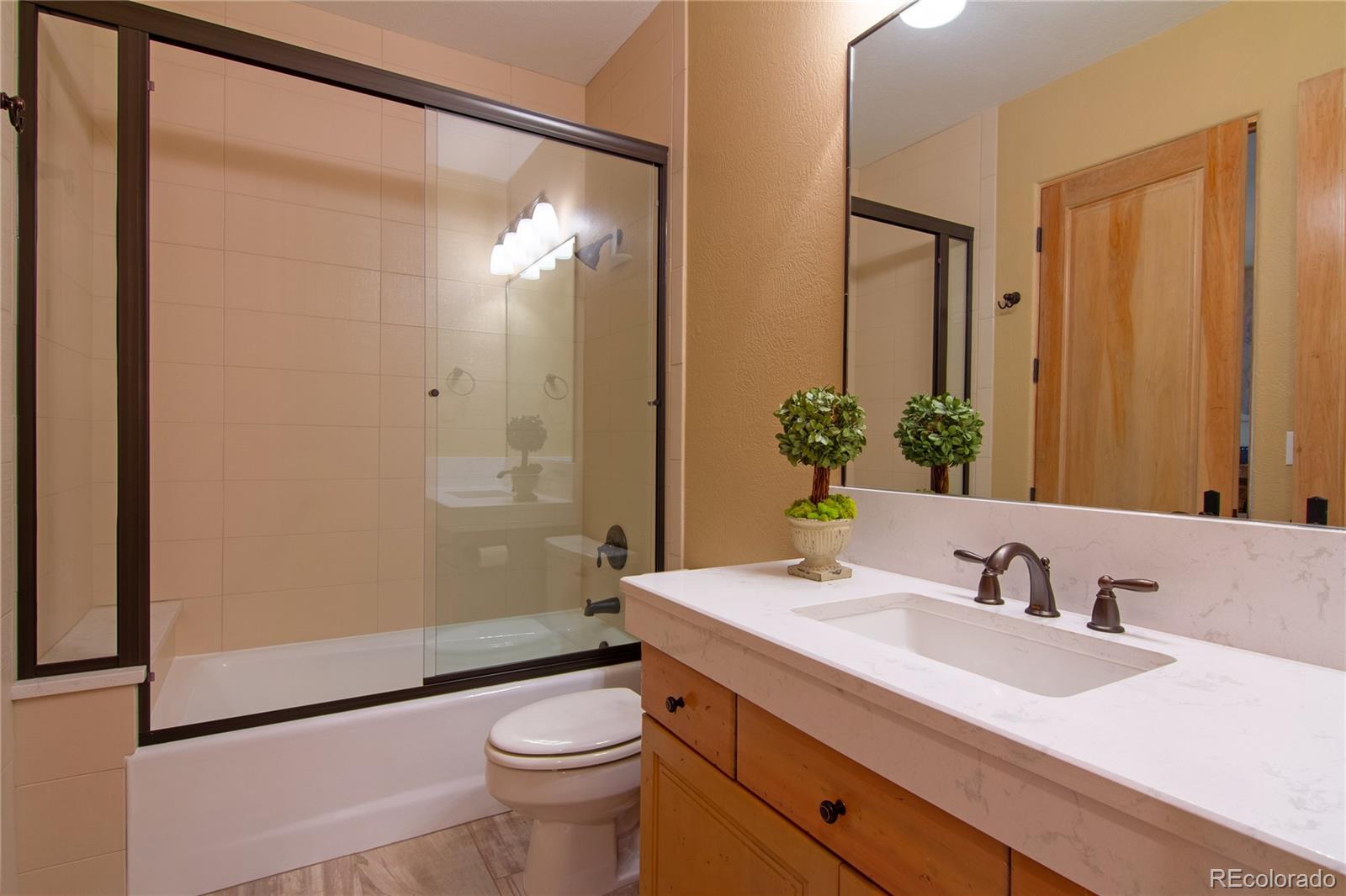 974 Spring Ranch Drive Golden, CO 80401 - Photo 20 of 35 a bathroom with a granite countertop sink toilet and shower