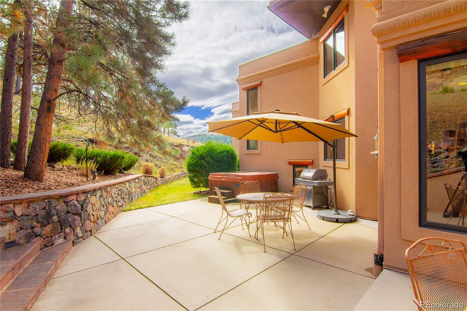 974 Spring Ranch Drive Golden, CO 80401 - Photo 31 of 35 a view of a patio with a table and chairs under an umbrella