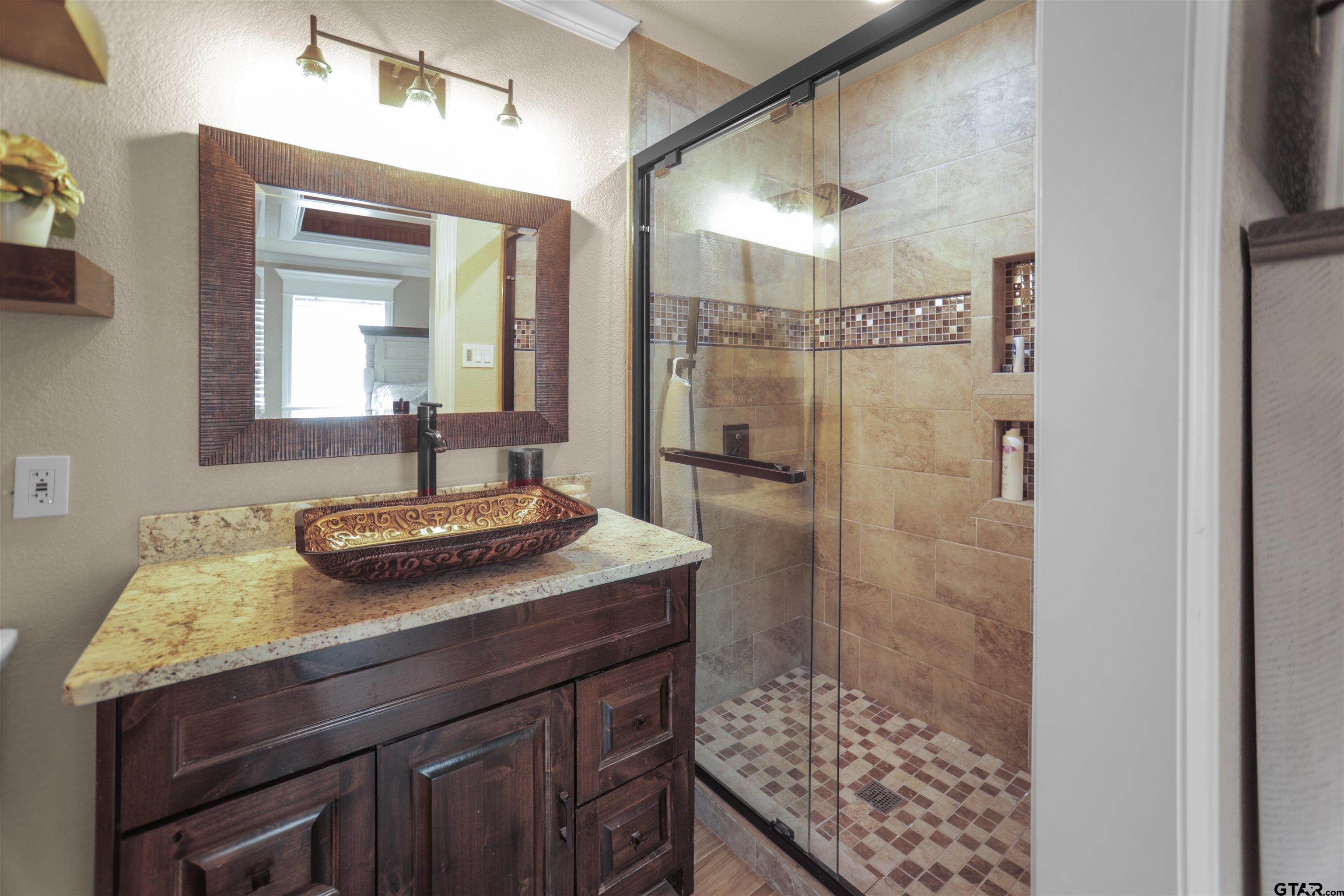 11931 State Highway 64 Tyler, TX 75704 - Photo 14 of 44 a bathroom with a sink a mirror and shower