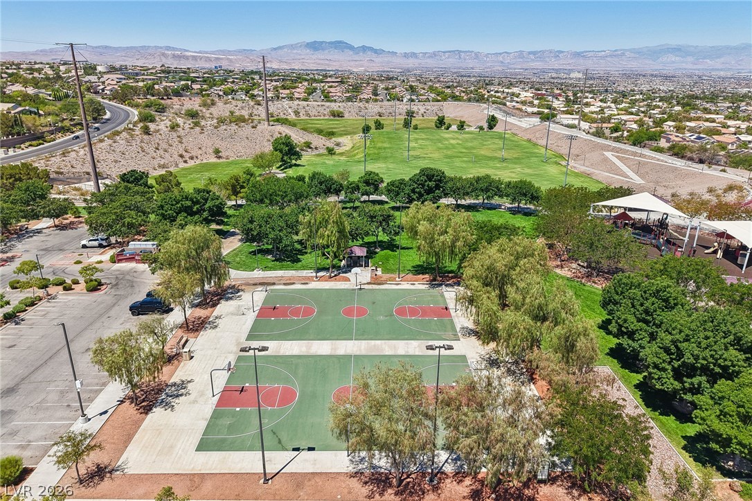 1176 Butternut Ranch Court Henderson, NV 89052 - Photo 57 of 60 An aerial perspective showcases the dual basketball courts nestled within a community park, bordered by lush green spaces and distant mountain views.