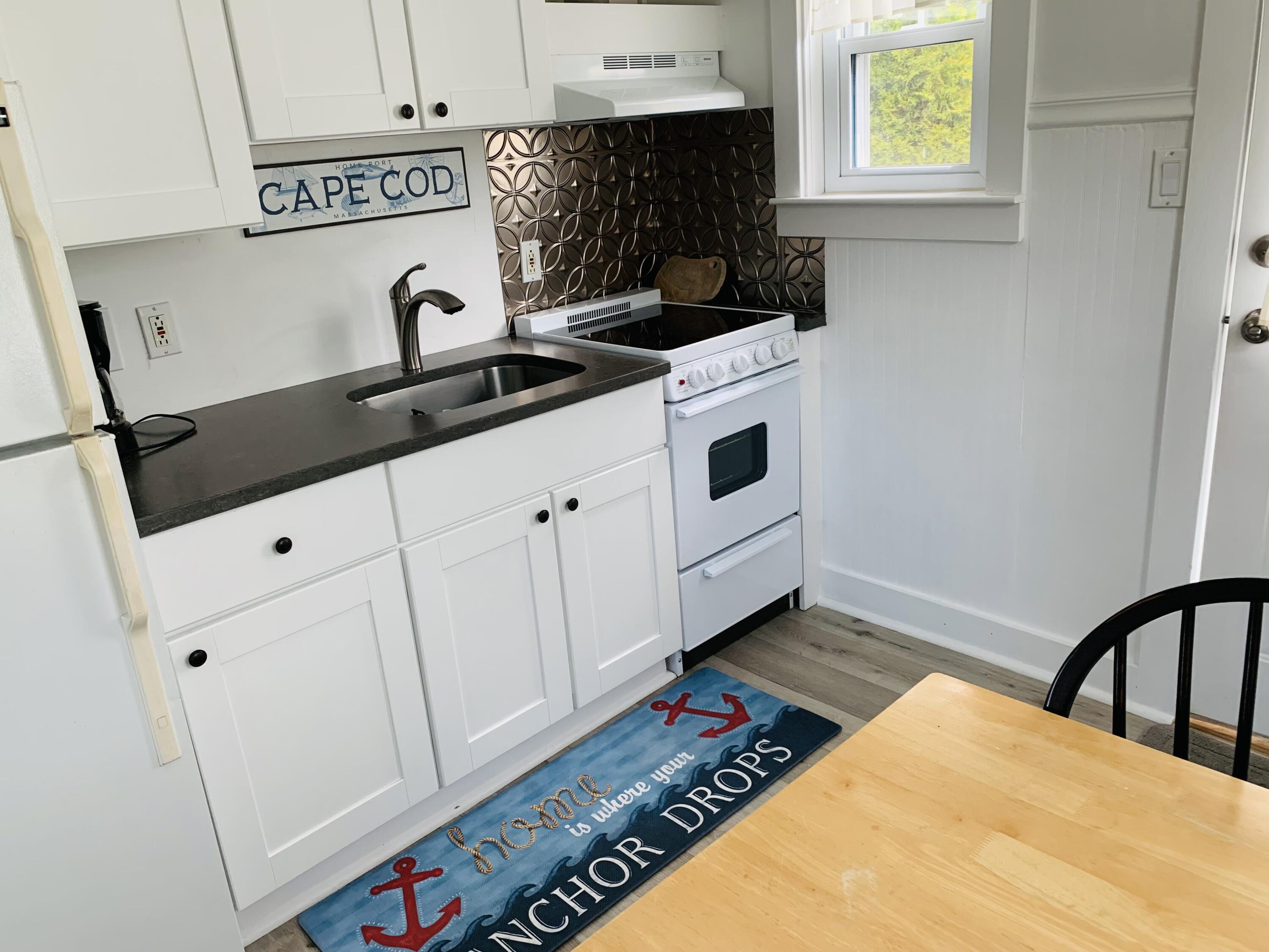 120 Bearses Way Hyannis, MA 02601 - Photo 2 of 11 a kitchen with granite countertop a stove a sink and a microwave