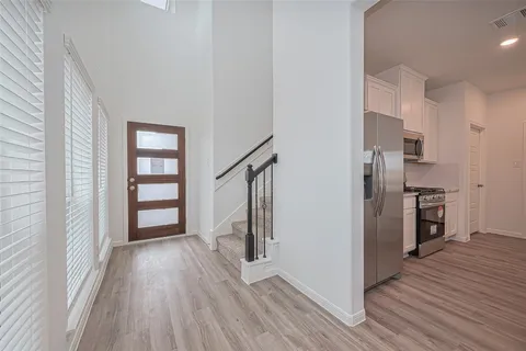 a view of kitchen with refrigerator and wooden floor