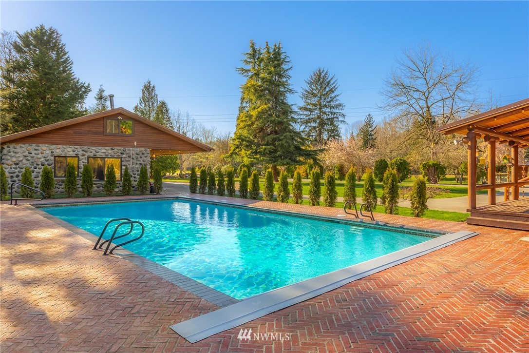 18700 Byers Road Southeast Maple Valley, WA 98038 - Photo 5 of 40 a view of swimming pool with lawn chairs under an umbrella