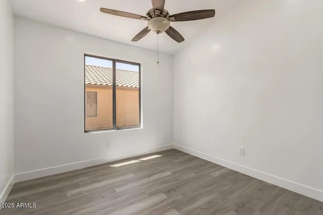 an empty room with a window and a fan