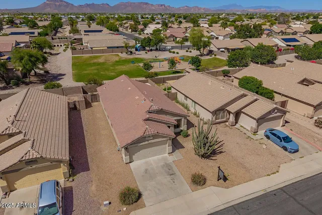 an aerial view of a house with garden space and mountain view in back