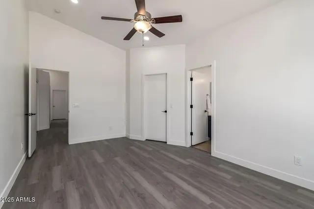 an empty room with wooden floor a ceiling fan and closet