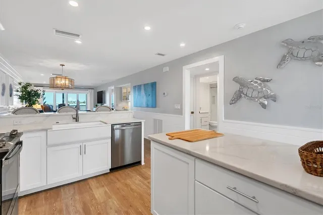 a kitchen with white cabinets and sink