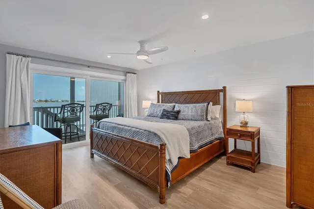 a large bed sitting in a bedroom next to a window with table and chairs