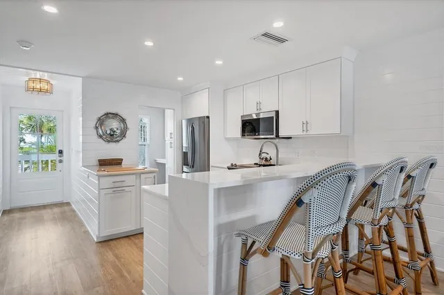 a kitchen with stainless steel appliances granite countertop a refrigerator a stove top oven a sink and dishwasher