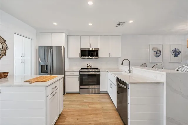 a kitchen with stainless steel appliances granite countertop a sink stove and refrigerator