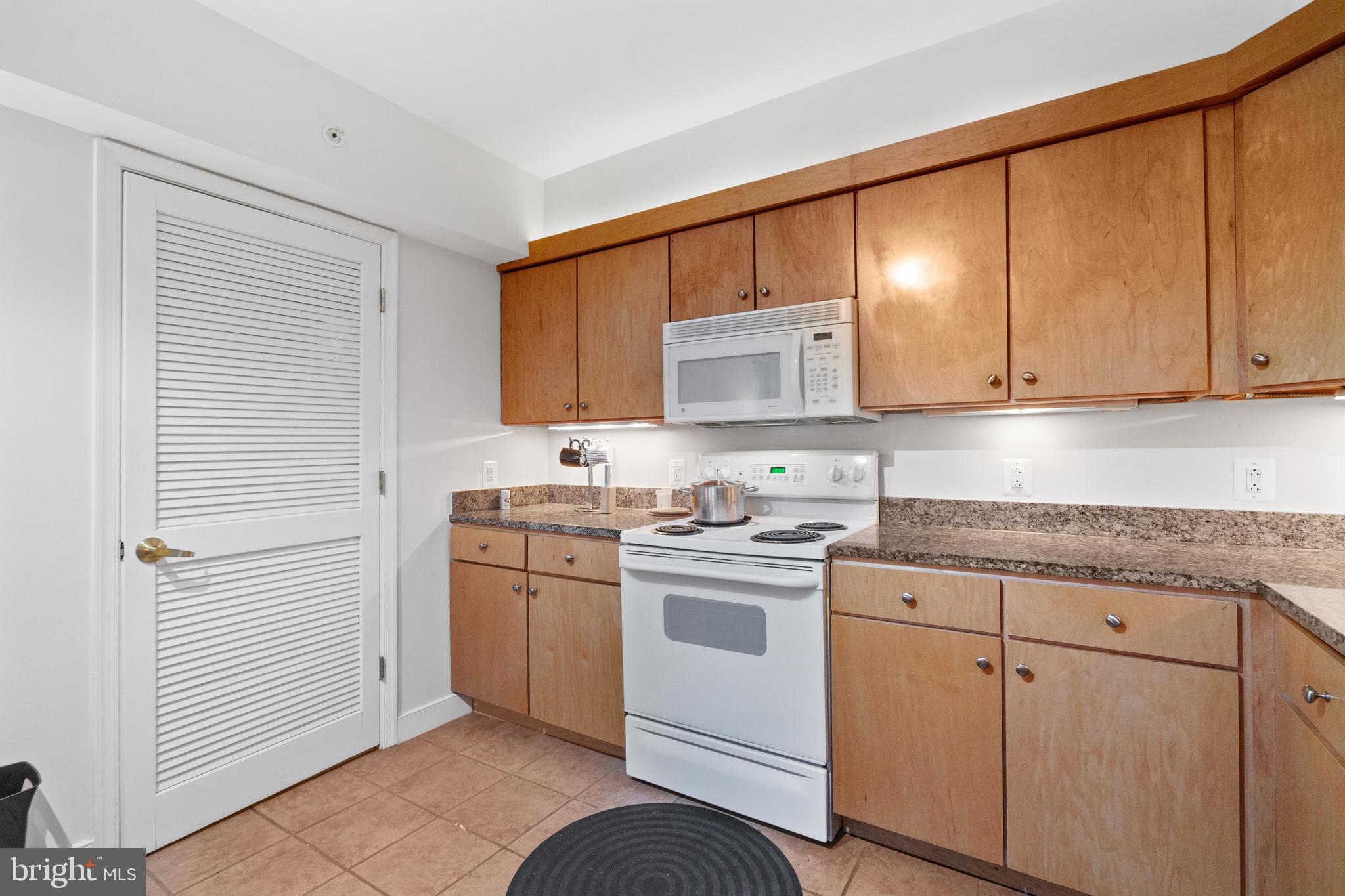 616 E Street Northwest, Unit 304 Washington, DC 20004 - Photo 20 of 53 a kitchen with white cabinets and white appliances