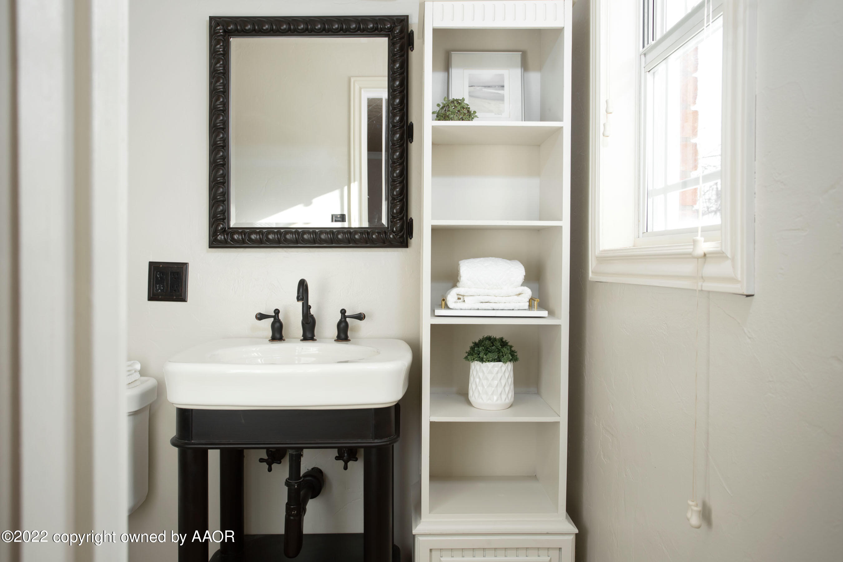 6301 Dreyfuss Road Amarillo, TX 79106 - Photo 17 of 34 a bathroom with a sink a mirror and a window