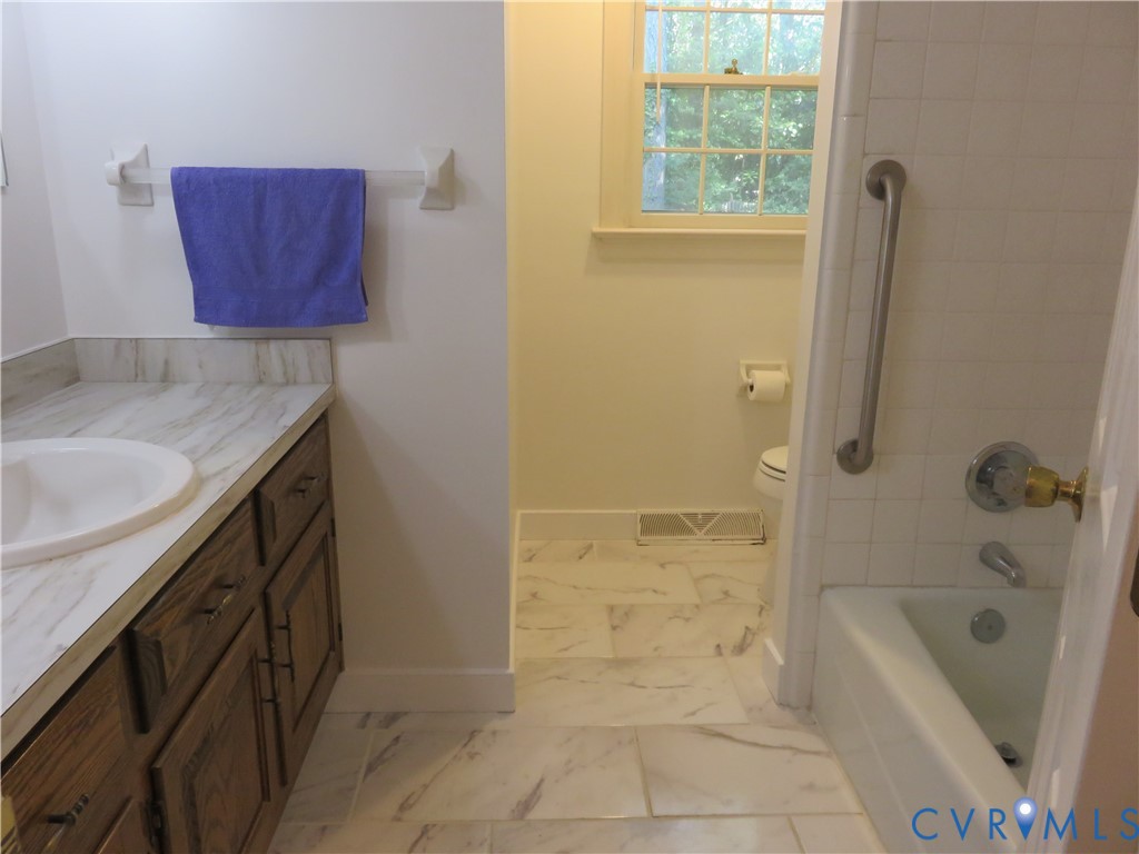 8379 Quailfield Road Mechanicsville, VA 23116 - Photo 31 of 56 a bathroom with a granite countertop sink a toilet and bathtub