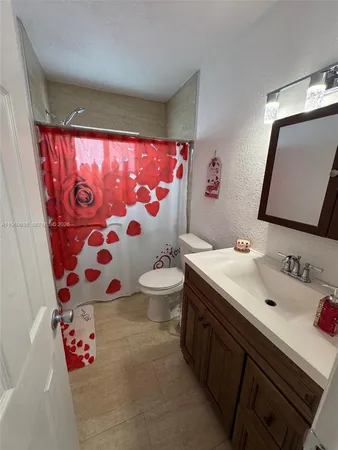 a bathroom with a sink and mirror with toilet