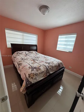 a bed sitting in a bedroom next to a window