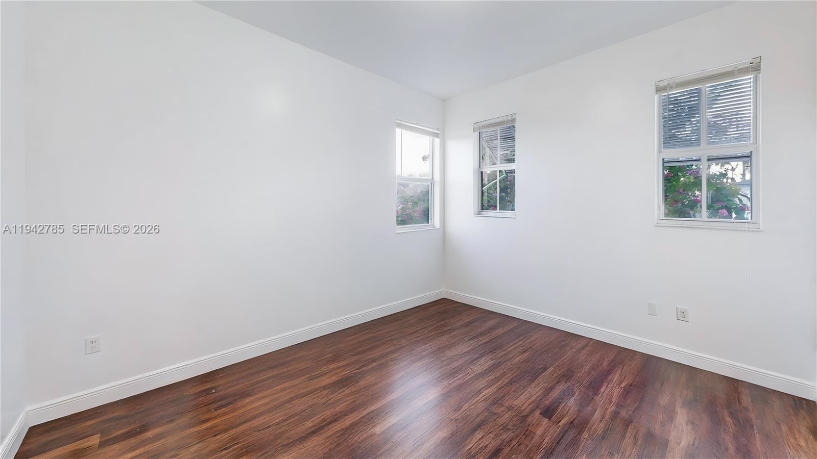 231 Northeast 33rd Terrace Homestead, FL 33033 - Photo 46 of 87 an empty room with wooden floor and windows