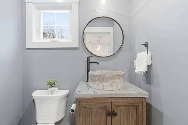 a bathroom with a toilet a sink and a mirror
