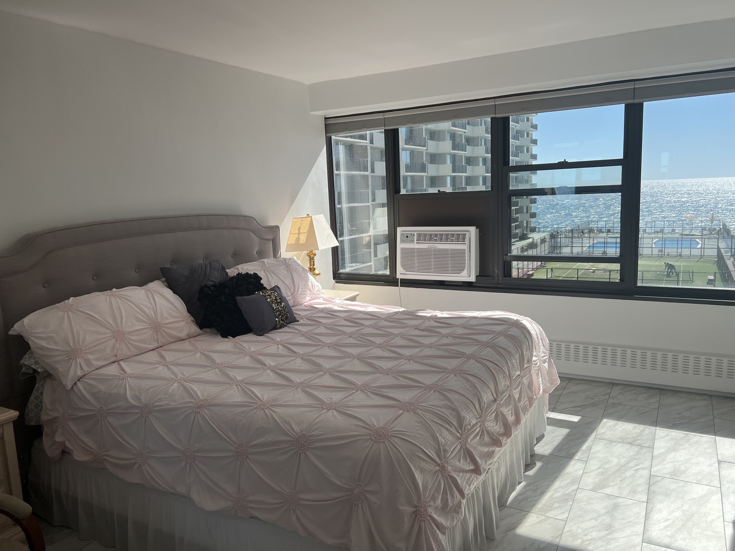 6030 North Sheridan Road, Unit 806 Chicago, IL 60660 - Photo 5 of 12 a large bed sitting in a bedroom next to a large window