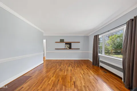 a view of hallway with a large window and wooden floor
