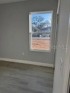 a view of a small space with wooden floor and a window