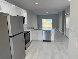 a kitchen with stainless steel appliances a refrigerator sink and cabinets