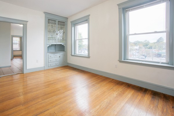 7-9 University Road Brookline, MA 02445 - Photo 4 of 17 a view of an empty room with a window and wooden floor