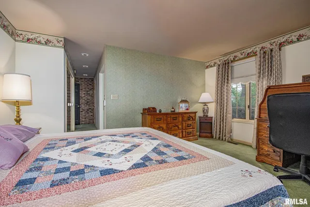 a bedroom with a bed and a flat tv screen on dresser