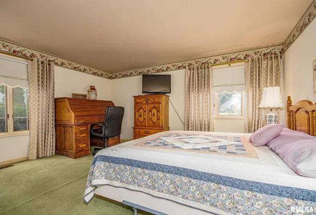 a bedroom with a bed dresser and a window