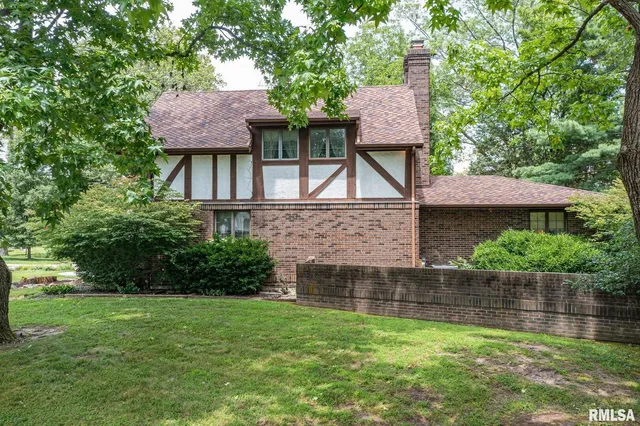 a front view of a house with a yard and trees