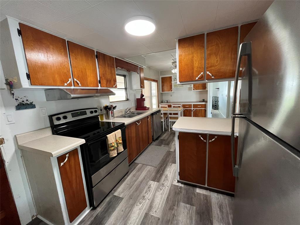 1910 Southwest 85th Terrace Davie, FL 33324 - Photo 4 of 22 a kitchen with stainless steel appliances granite countertop wooden cabinets sink and stove