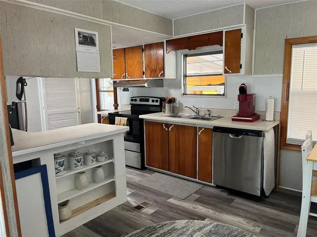 a kitchen with a stove a table and chairs in it