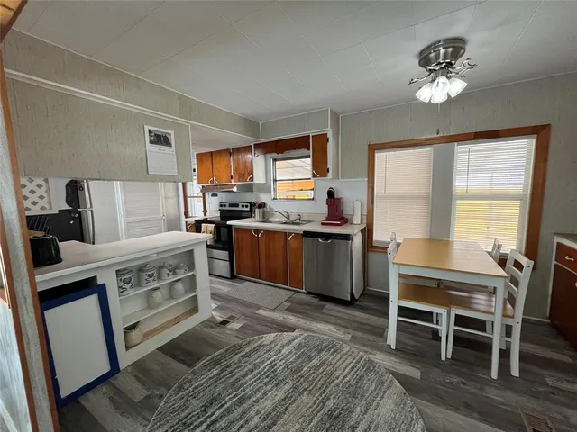 a kitchen with a table chairs a sink dishwasher window and cabinets