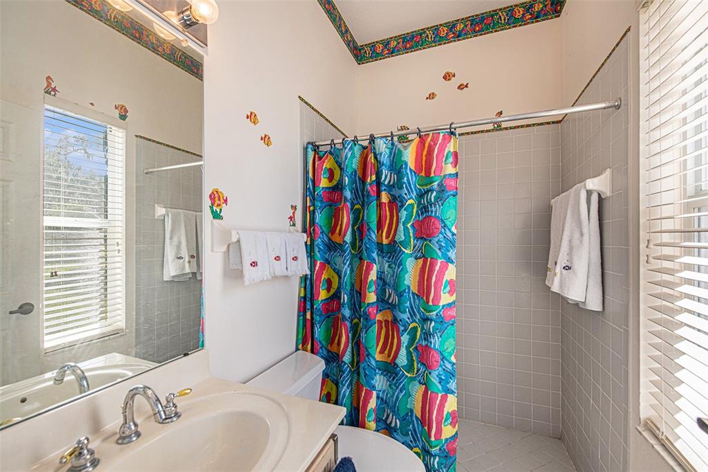 331 Lewis Road Lithia, FL 33547 - Photo 27 of 87 a bathroom with a sink a toilet and shower curtain
