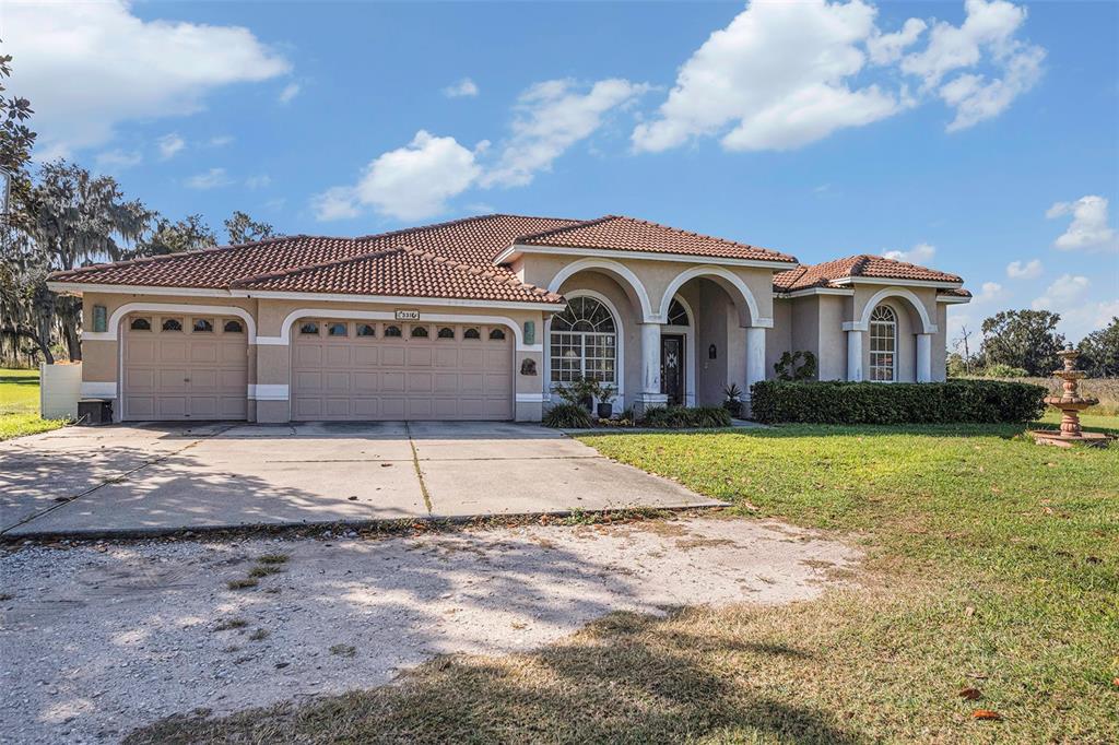 331 Lewis Road Lithia, FL 33547 - Photo 5 of 87 a front view of a house with a yard and garage