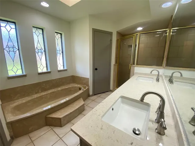 a bathroom with a tub sink and mirror