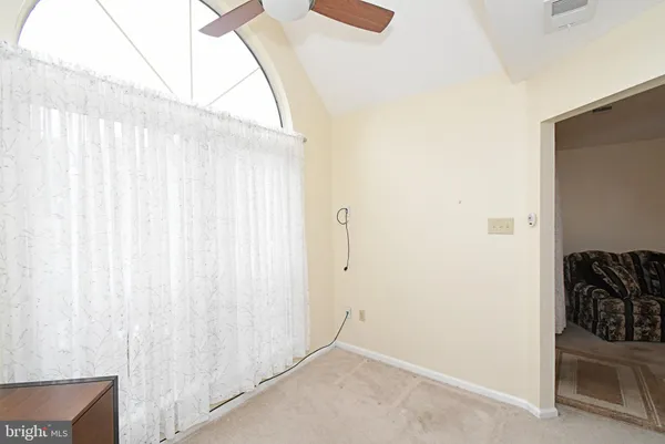 an empty room with a ceiling fan and a window