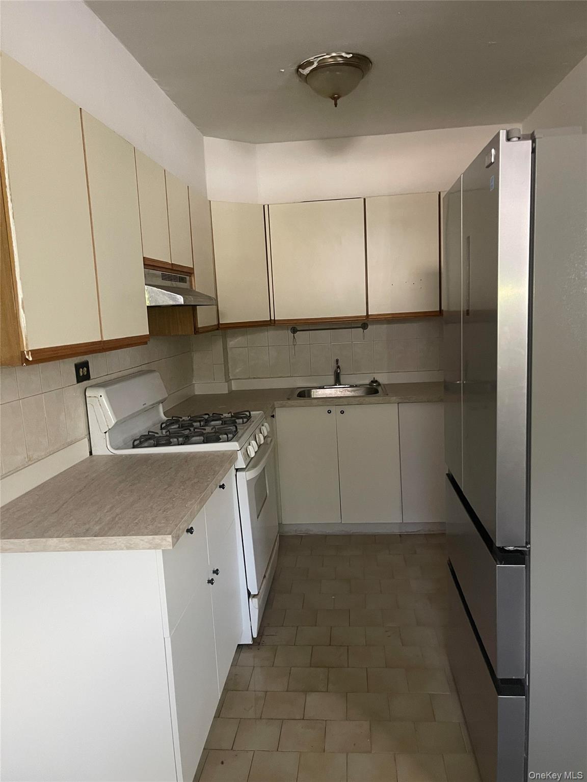 152-72 Melbourne Avenue, Unit LD Queens, NY 11367 - Photo 7 of 10 a kitchen with a sink stainless steel appliances and cabinets