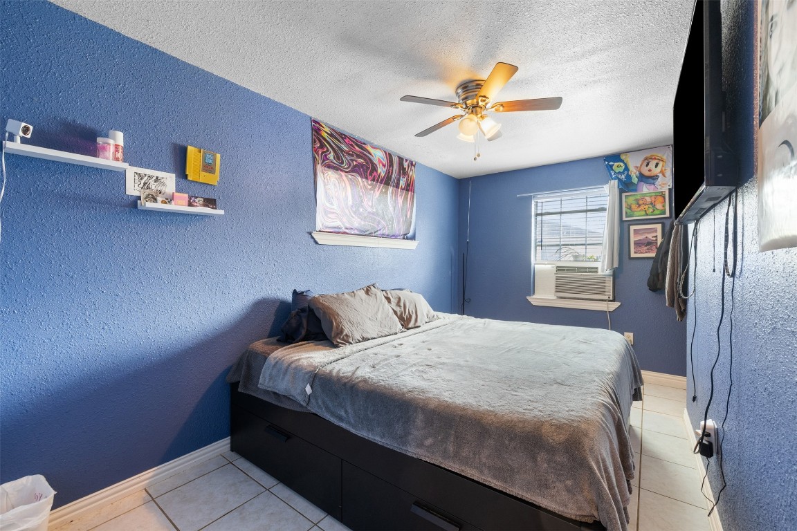 3367 Sadler Street Houston, TX 77093 - Photo 10 of 25 a bedroom with a bed and a chandelier