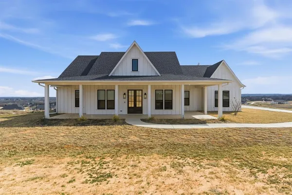 a front view of a house with a garden and yard