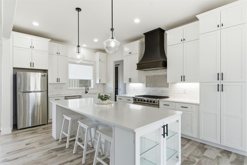 1024 Agnes North Springtown, TX 76082 - Photo 12 of 36 a kitchen with stainless steel appliances granite countertop a stove sink refrigerator and cabinets