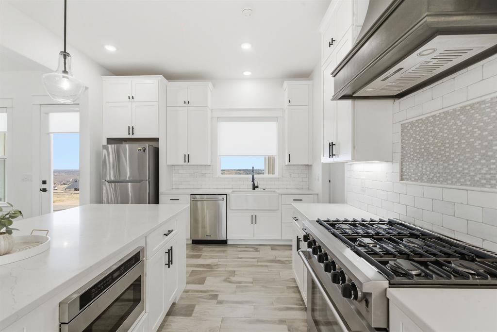 1024 Agnes North Springtown, TX 76082 - Photo 14 of 36 a large kitchen with stainless steel appliances granite countertop a stove a sink dishwasher and a refrigerator