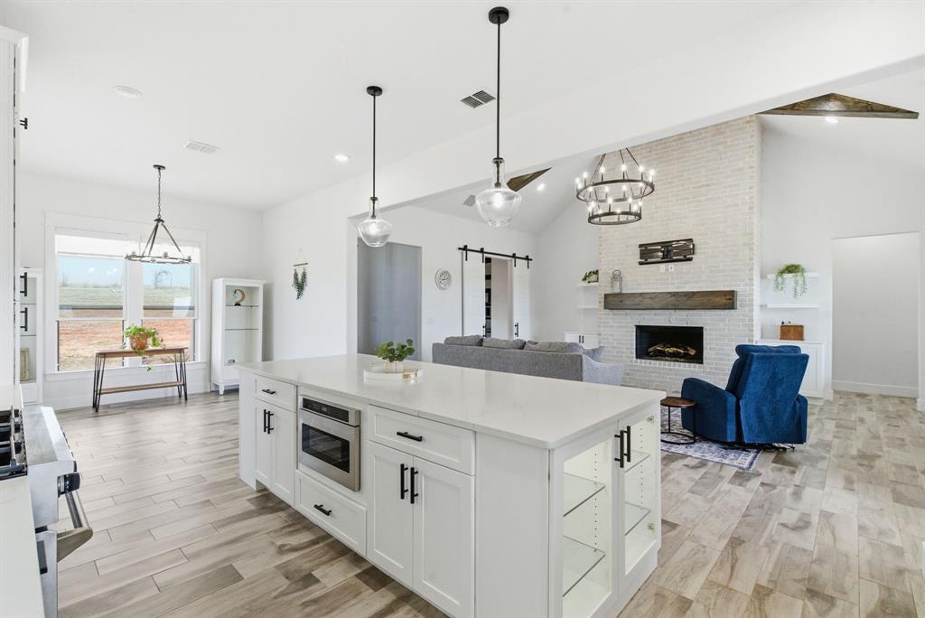 1024 Agnes North Springtown, TX 76082 - Photo 16 of 36 a large white kitchen with a stove and a wooden floor