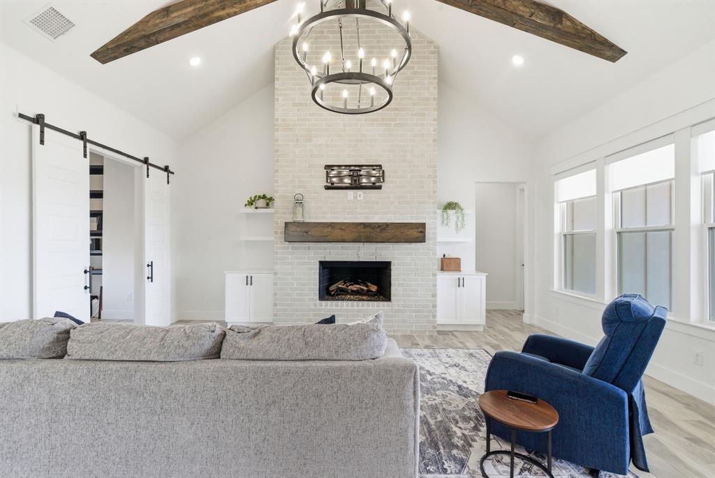 1024 Agnes North Springtown, TX 76082 - Photo 6 of 36 a living room with furniture a table and a fireplace