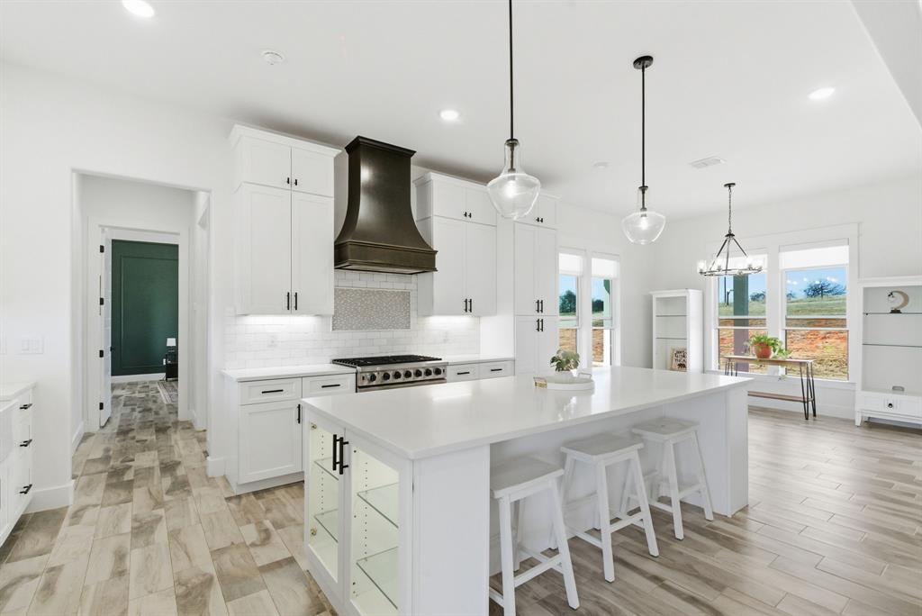 1024 Agnes North Springtown, TX 76082 - Photo 10 of 36 a kitchen with stainless steel appliances kitchen island a stove a sink a center island and a wooden floor