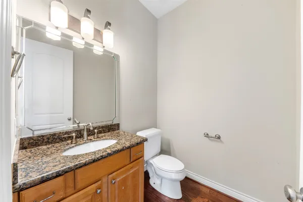 a bathroom with a granite countertop sink a toilet and a mirror