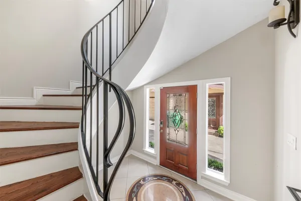 a view of staircase with railing and white walls
