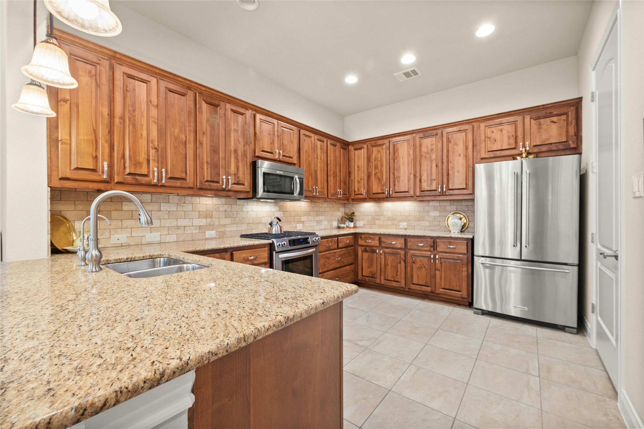 103 Rivalto Circle, Unit 3 Lakeway, TX 78734 - Photo 12 of 30 a kitchen with a refrigerator a stove a sink a center island and a cabinets