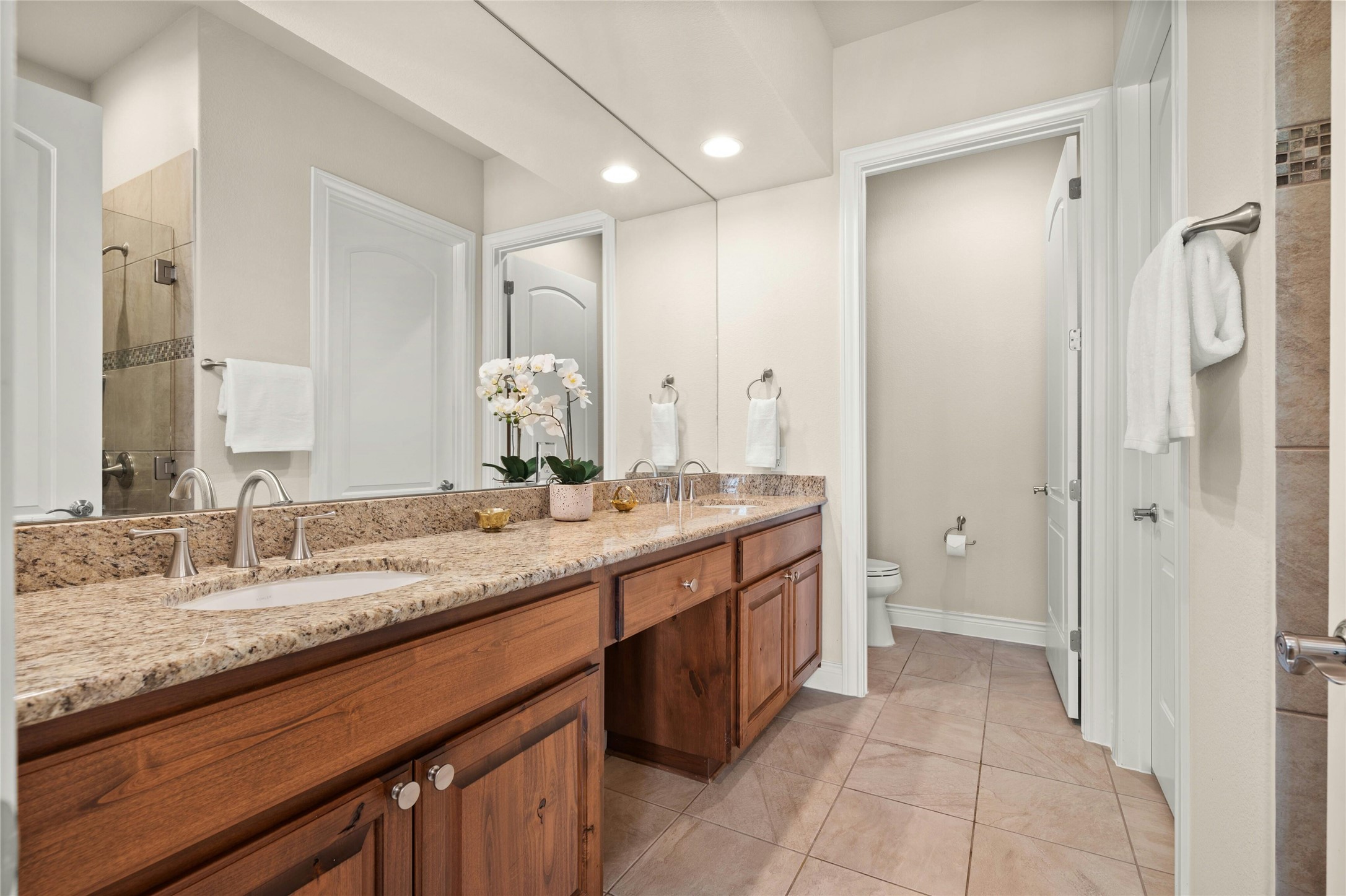 103 Rivalto Circle, Unit 3 Lakeway, TX 78734 - Photo 18 of 30 a bathroom with a granite countertop sink and a mirror