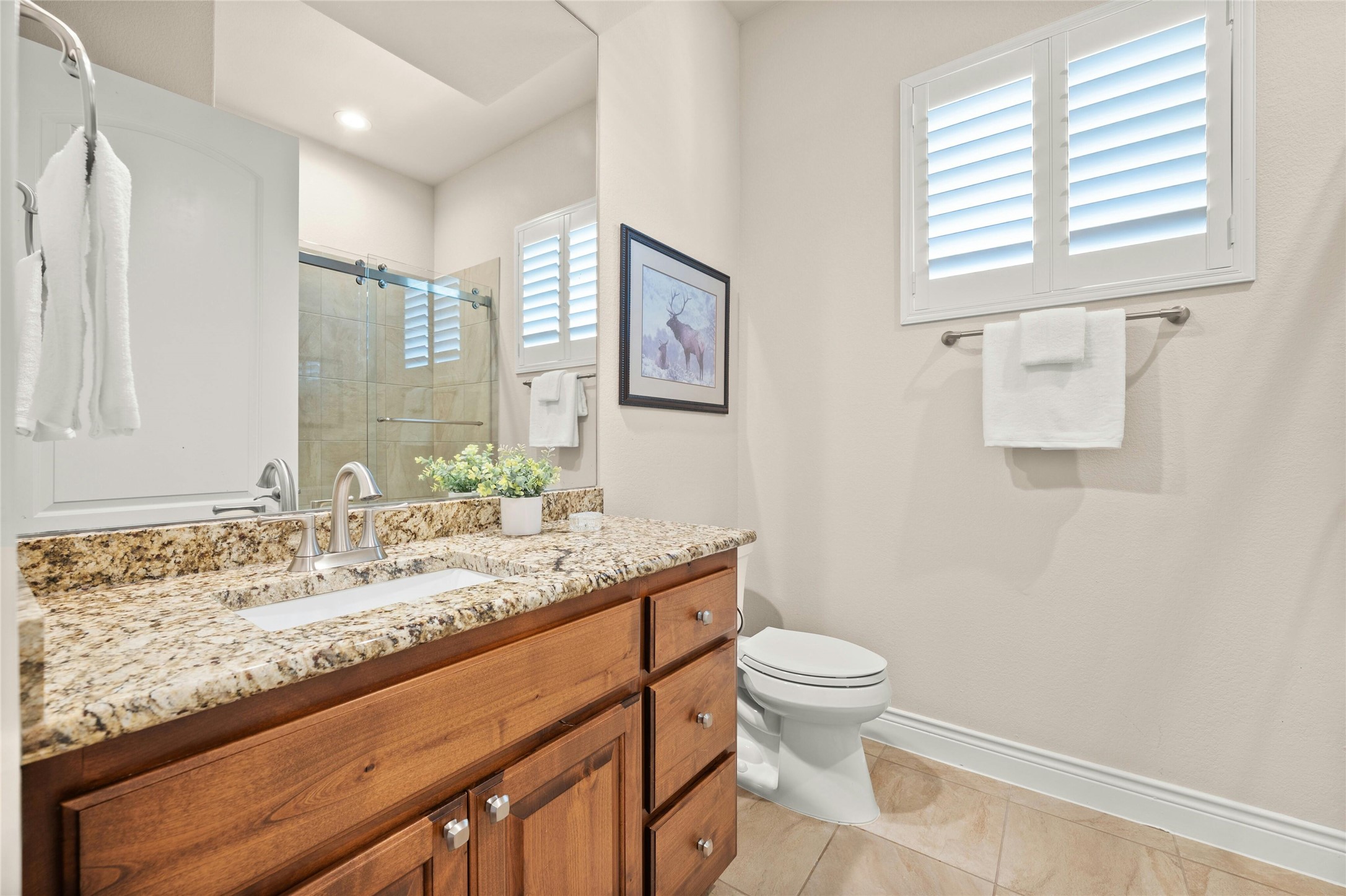 103 Rivalto Circle, Unit 3 Lakeway, TX 78734 - Photo 23 of 30 a bathroom with a granite countertop sink toilet and mirror