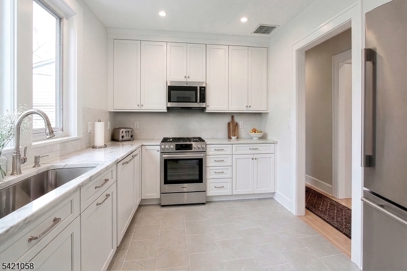 10 Lincoln Street Glen Ridge, NJ 07028 - Photo 3 of 28 a kitchen with white cabinets and white appliances